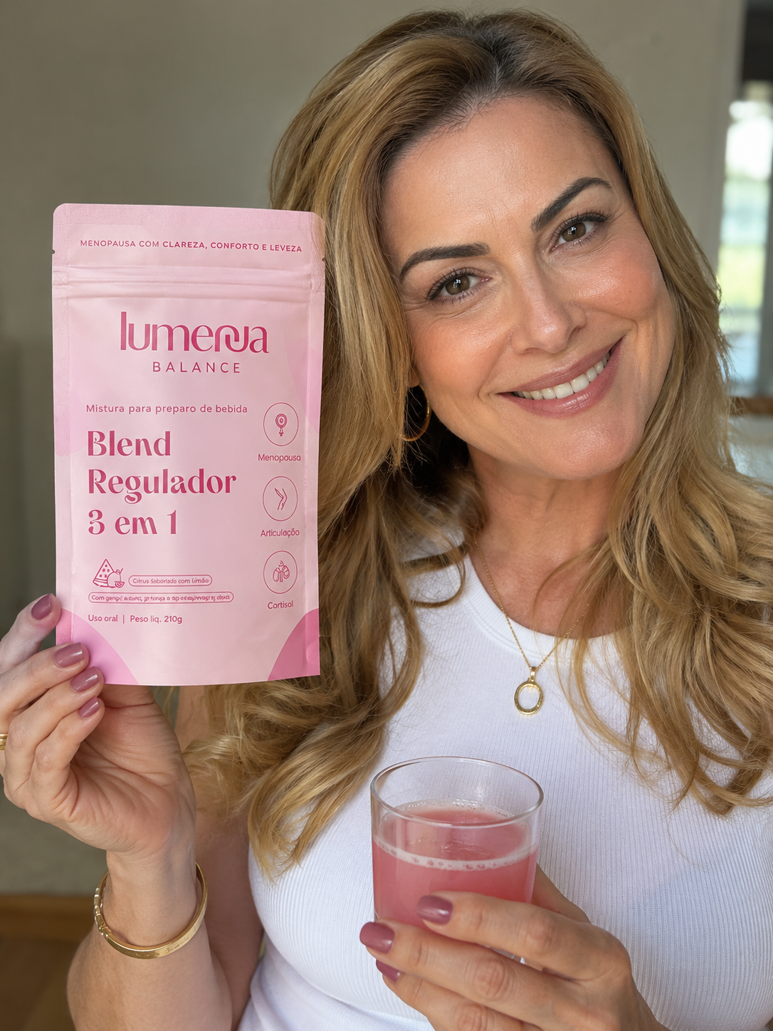 Mulher sorrindo segurando Lumenna Balance e drink rosa de melancia